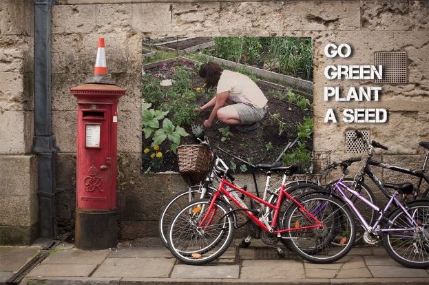 Mehrere Fahrräder sind in der Nähe eines Briefkastens mit einer Sicherheitsboje darauf geparkt; im Hintergrund ist eine Wand mit einem Plakat und ein Weg am unteren Rand des Bildes zu sehen.