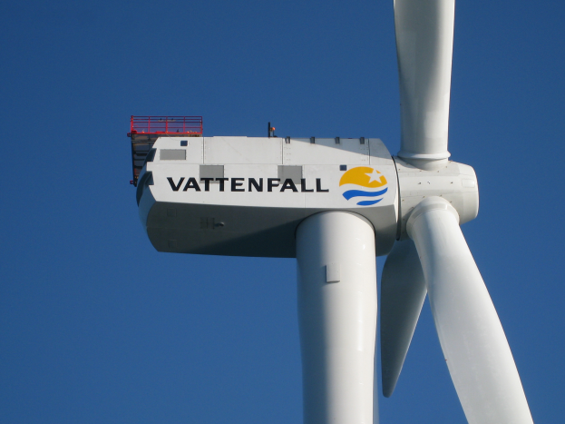 Eine weiße Windkraftanlage mit dem Wort "Vattenfall" darauf steht gegen einen hellblauen Himmel.