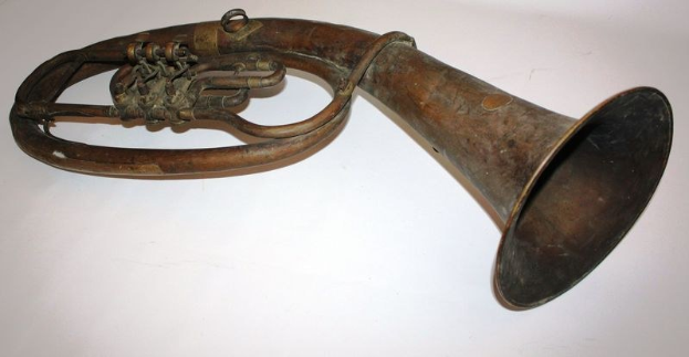 Altes Messinghorn mit glänzendem Finish, gebogener Hals und aufgeblähter Glocke, verziert mit kunstvollen Gravuren, auf einem weißen Hintergrund.