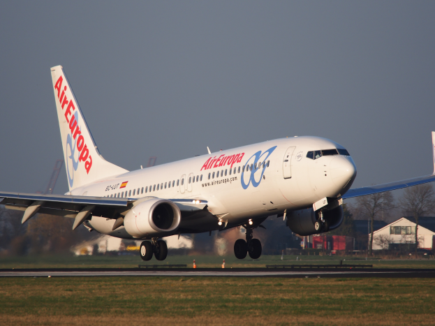 Ein Airbus A330-300 der Air Europa startet vom Frankfurter Flughafen, mit Gras darunter, Gebäuden und Bäumen im Hintergrund und einem klaren blauen Himmel darüber.