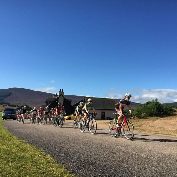 Eine Gruppe von Menschen, die mit einem klaren Himmel im Hintergrund Fahrrad fahren.