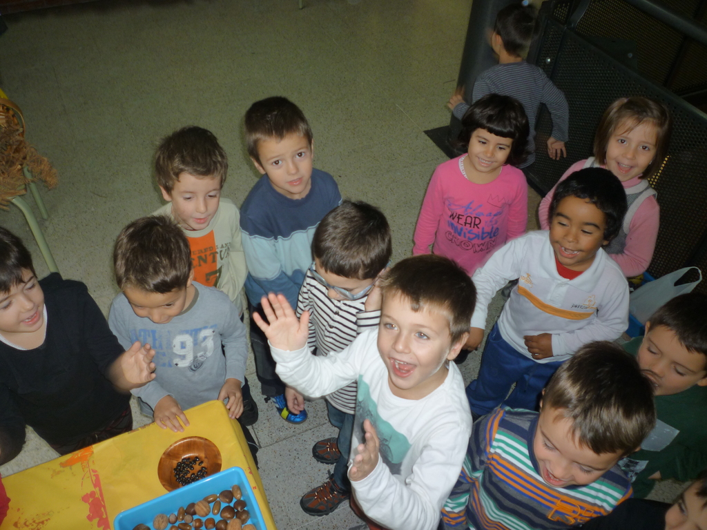 Kinder, die in der Nähe eines Tisches mit verschiedenen Gegenständen darauf stehen.