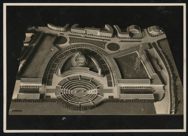 Schwarzes und weißes Rahmenfoto eines detaillierten Modellkonzerthauses mit einer großen zentralen Kuppel und steinernen Wänden, umgeben von einem Metalldach und einer Menge, mit einer hell erleuchteten Bühne.