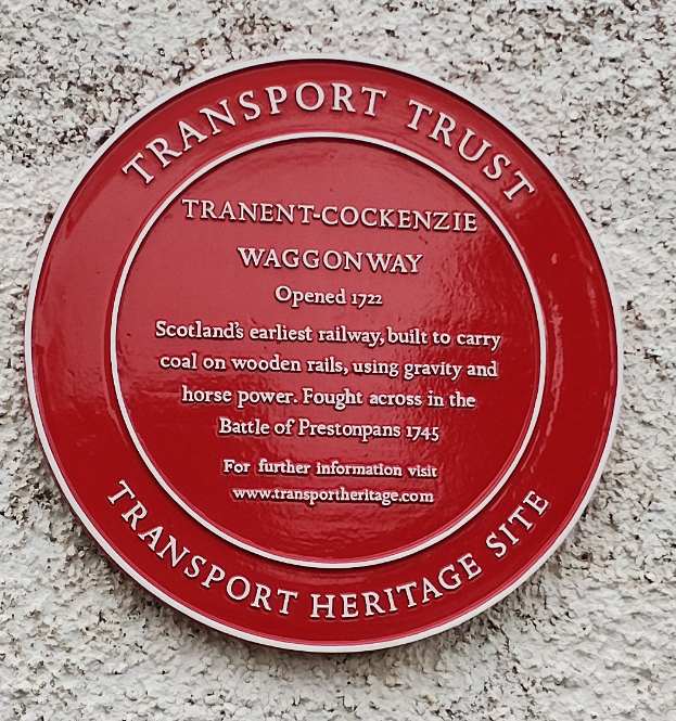 Ein rotes rundes Schild an einem Gebäude mit der Aufschrift "Transport Trust".