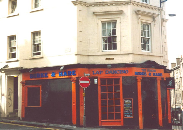 Ein Geb√§ude mit Fenstern, T√ľren und Text auf seiner Fassade.