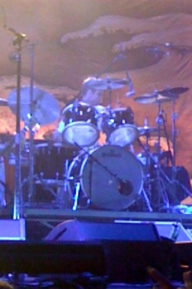 Eine Person sitzt hinter einem Schlagzeug mit verschiedenen Drogen drumherum.