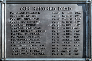 Gedenktafel an einer Gebäudeseite mit der Inschrift "Unser Ehrwürdiger Toten" aus Metall.