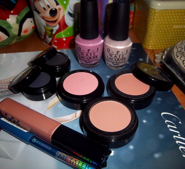 Ein Make-up-Set und mehrere Nagellackflaschen sind auf einem Magazin auf einer Oberfläche platziert.