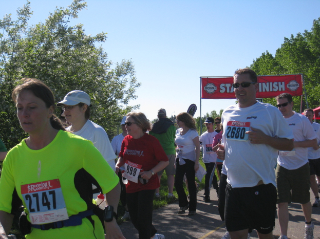Eine Gruppe von Kindern beim Marathonlauf mit einem roten Banner und Bäumen im Hintergrund.