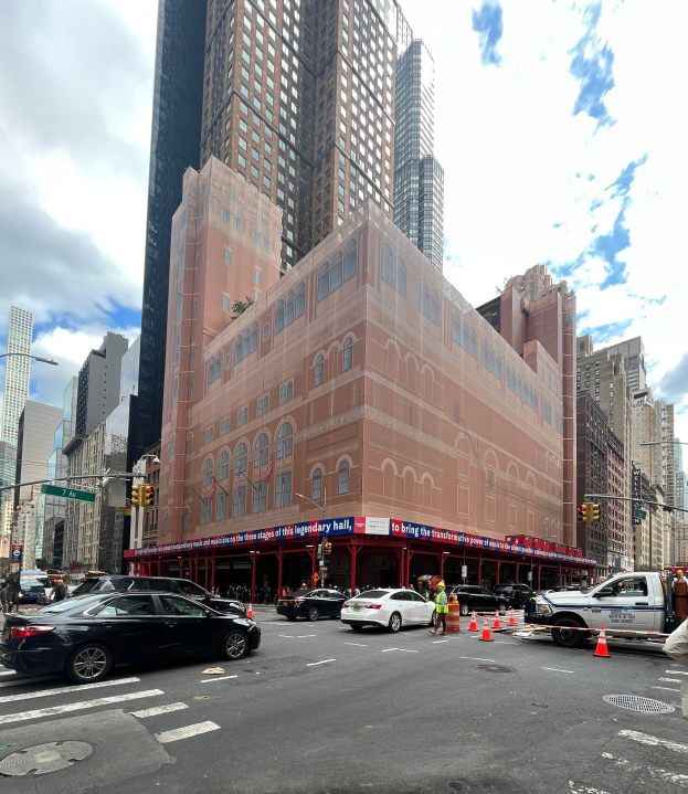 Eine belebte Stadtstraße mit hohen Gebäuden, Fahrzeugen, Fußgängern und verschiedenen städtischen Elementen, mit einem prominenten Gebäude in der Mitte, das das legendäre Hall in New York City zu sein scheint, unter einem bewölkten Himmel mit einem Wasserzeichen.