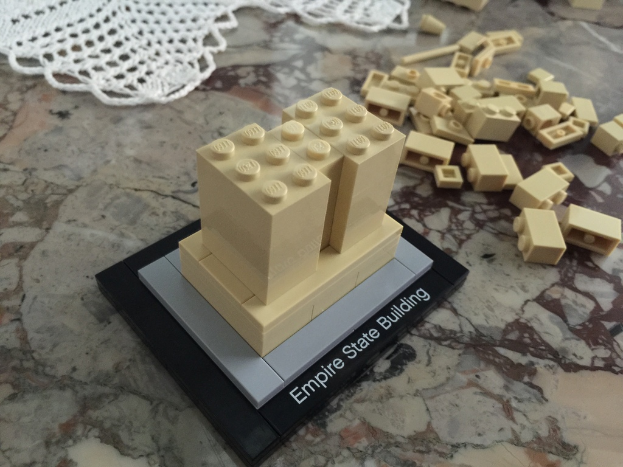 Bauklotzsteine auf einer Oberfläche angeordnet mit mehr Steinen und einem wollenen Tuch im Hintergrund.