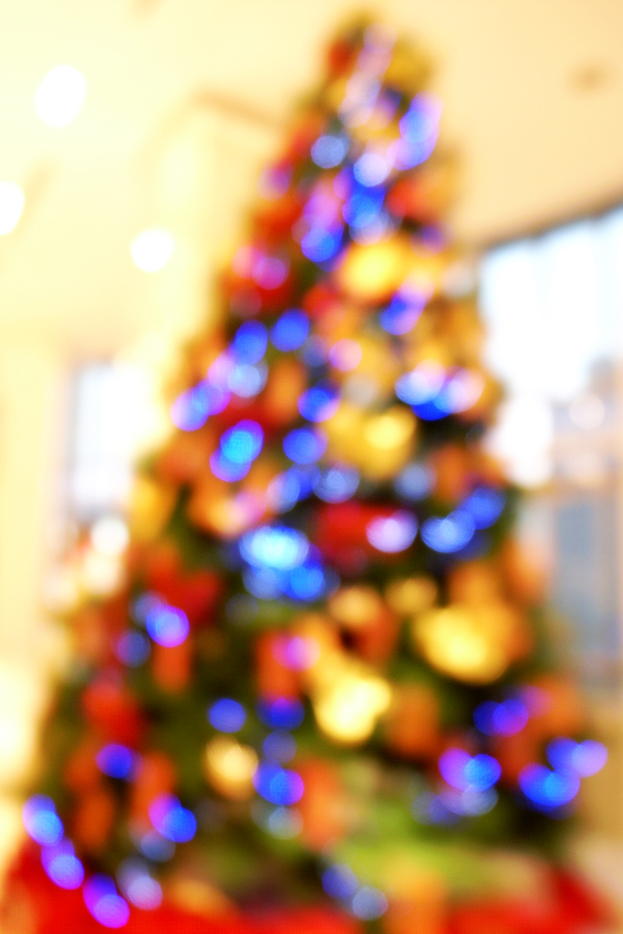 Ein unscharfer Schnappschuss eines drinnen geschmückten Weihnachtsbaums.