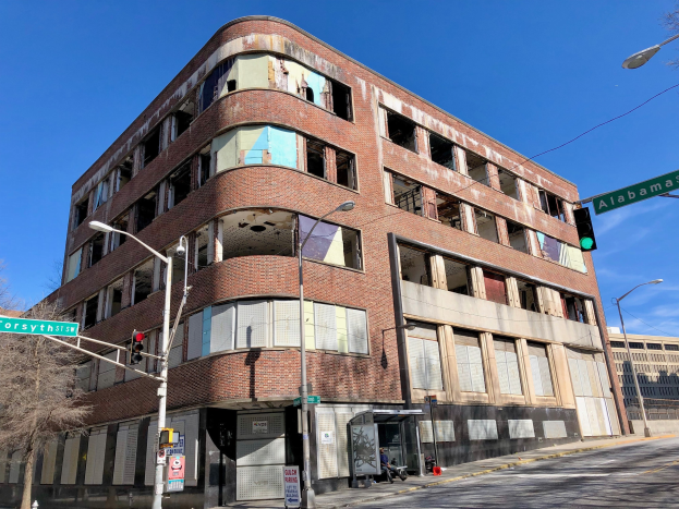 Altes Backsteingebäude an der Ecke einer Straße, das als ehemalige Hauptverwaltung der University of Illinois at Chicago markiert ist, mit umgebender Straßeninfrastruktur und Fahrzeugen.