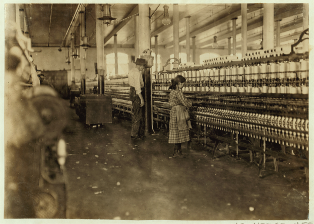 Zwei Frauen bei der Arbeit in einer Fabrik umgeben von Maschinen und Geräten, mit Text unten auf dem Bild.