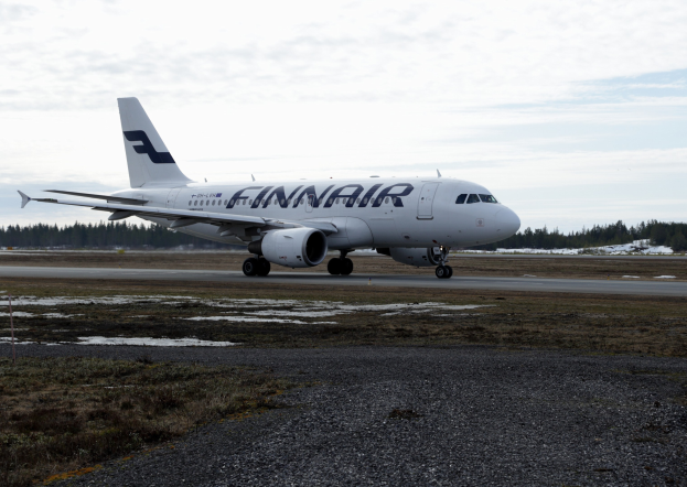 Finnair Airbus A320-200 auf der Rollbahn am Seattle-Tacoma International Airport mit grünem Gras, B├Ąumen und einem klaren blauen Himmel im Hintergrund.