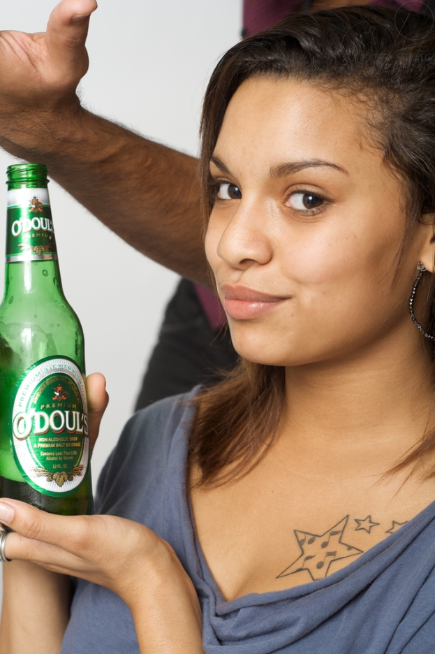 Eine Frau in einem blauen Kleid hält eine Flasche.