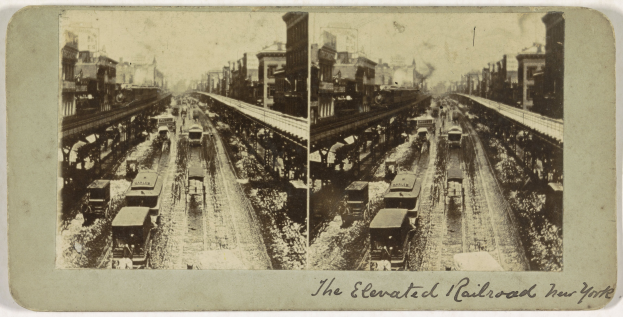 Schwarzes und weißes Foto eines Zuges auf einer erhöhten Eisenbahnstrecke in New York City mit mehreren Fahrzeugen auf den Schienen, Menschen und Gebäuden im Hintergrund sowie Text am unteren Rand.