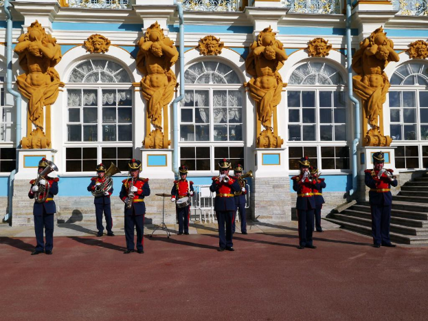 Menschen, die Instrumente in der Mitte spielen, mit einem Gebäude im Hintergrund und einem Boden unten, mit Darstellungen oben auf dem Bild.