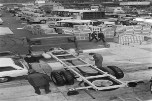 Schwarzes und weißes Foto von Männern, die an einem Truck in einer Fabrik arbeiten