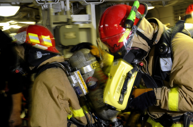 Feuerwehrleute in Schutzausrüstung arbeiten an einem Flugzeug während einer √Übungsausbildung.